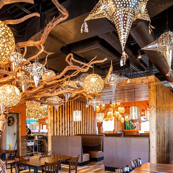 Azteca D'Oro Mexican Restaurant interior with ornate chandeliers, wooden accents, and booth seating.