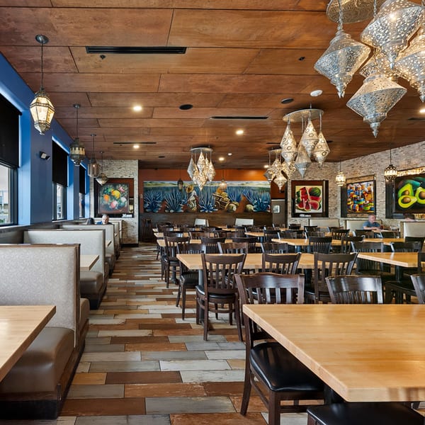 Spacious Azteca D'Oro Mexican restaurant interior with booths, tables, chairs, and Mexican-themed art and lighting.
