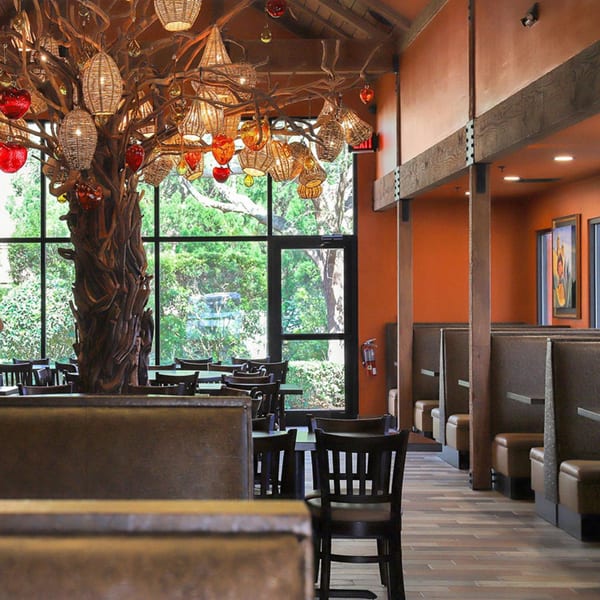 Azteca D'Oro Mexican Restaurant interior with a large decorative tree, tables, and booths.