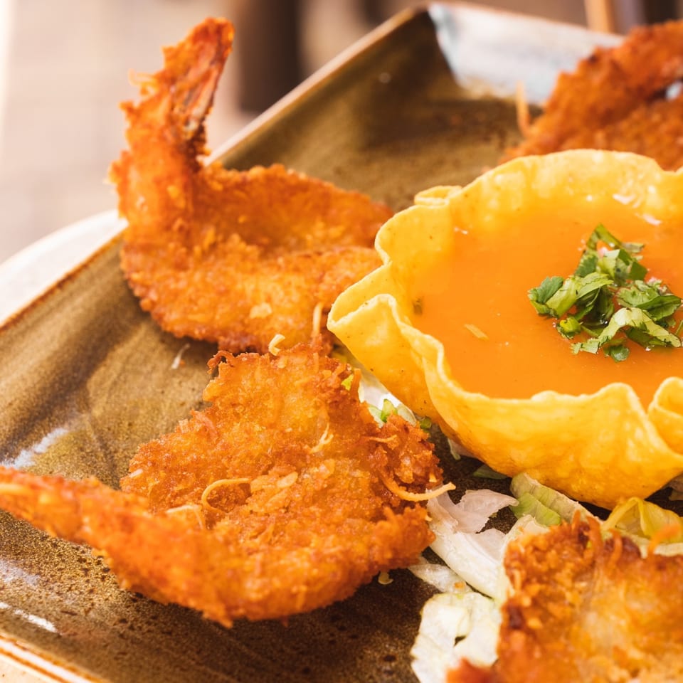 Crispy fried shrimp and a tortilla bowl filled with orange sauce and cilantro at Azteca D'Oro.